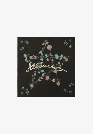 Czarny kwadrat z materiału z pastelowymi różowymi i niebieskimi kwiecistymi pnączami tworzącymi kształt gwiazdy oraz kremowym, kursywnym napisem na środku.