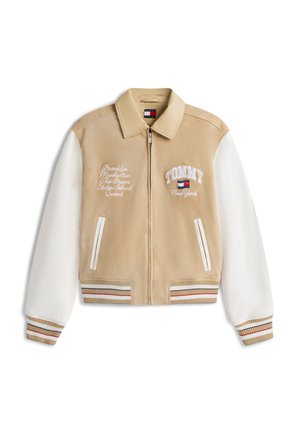 Chaqueta bomber beige y blanca con cremallera, puños acanalados a rayas, dos bolsillos delanteros y texto bordado que incluye "TOMMY New York" en el pecho.