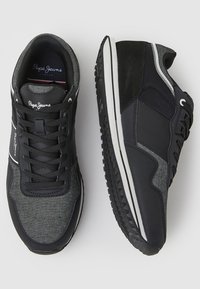 Black and gray athletic shoes with a textured fabric upper, synthetic accents, white sole stripes, and padded collar for comfort.