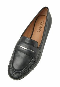 Mocassino in pelle nera con punta arrotondata, cuciture testurizzate, tacco piatto e un accento metallico sul davanti. Interno piatto e liscio.