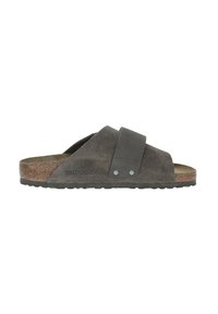 Sandales en daim gris avec une large sangle et un accent gris. Semelle intérieure en liège avec une semelle extérieure en caoutchouc texturé. Logo de la marque visible sur le côté.