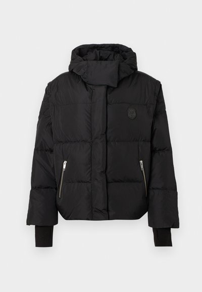 Μαύρο τζάκετ με φούτερ, με καπιτονέ υφή, τσέπες με φερμουάρ και ραβδωτές μανσέτες. Διαθέτει λογότυπο στη στήθος.