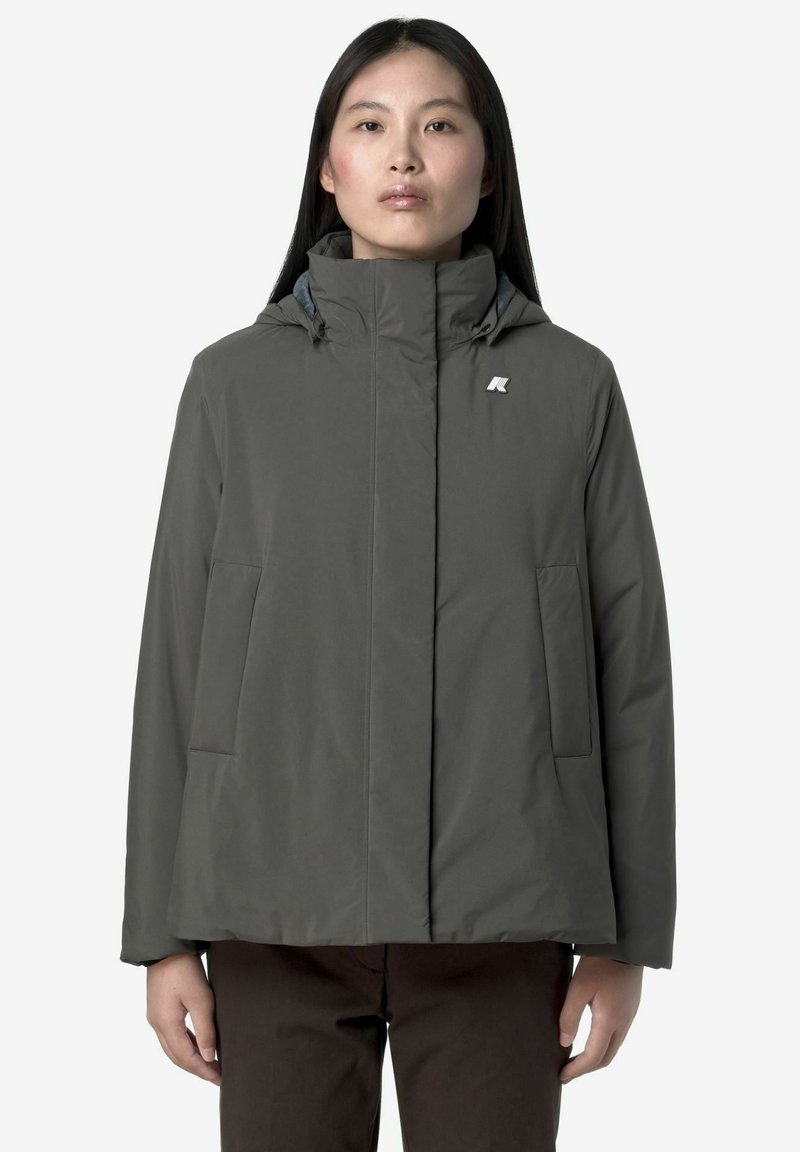 Veste à capuche gris foncé avec une finition lisse et texturée, comportant deux poches avant et un petit logo sur le côté gauche de la poitrine.