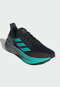 Black running shoe with mesh upper, turquoise accents, three stripes, thick sole with textured grey underside, and logo on tongue.