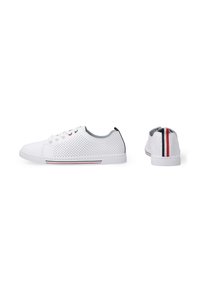 Weiße perforierte Sneakers mit grauem Innenfutter, roten und blauen Akzentstreifen an der Sohle und flachen Schnürsenkeln. Merkmale sind eine abgerundete Zehenpartie und eine flache Gummisohle.