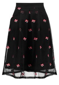 Gonna plissée nera con fiori rossi ricamati, con uno strato trasparente e una vita aderente, che mette in risalto gli accenti floreali.