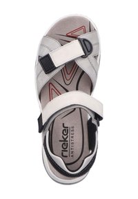 Sandali grigi chiari con cinturini in Velcro, soletta imbottita e suola testurizzata. Presentano un accento nero e elementi di design rossi sulla pianta.
