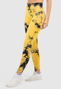 Strakke leggings in helder geel met zwarte marmerachtige patronen. Gemaakt van rekbare stof en voorzien van een hoge tailleband.