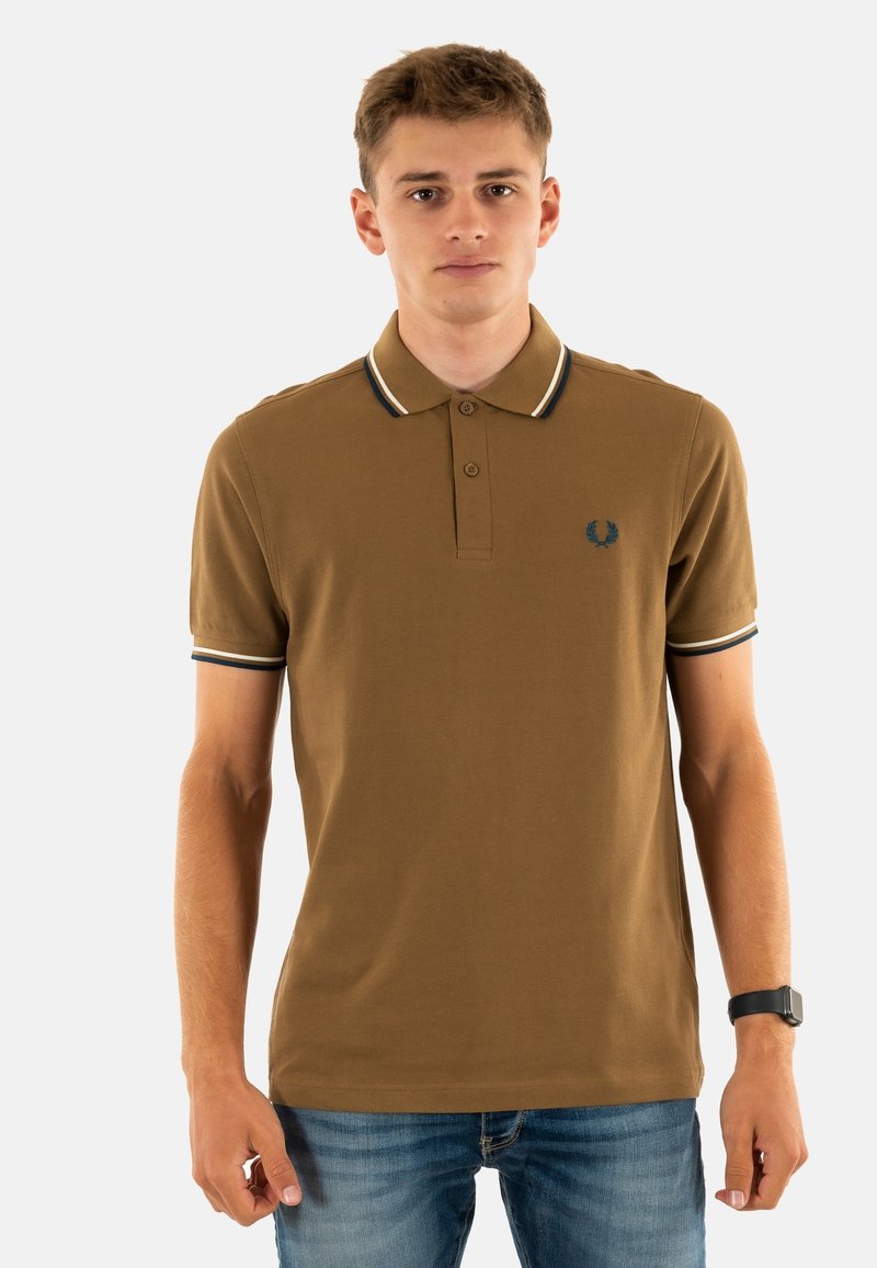 Bruine poloshirt met een tweeknopssluiting, geribde kraag en manchetten met zwart-witte strepen. Inclusief een logo op de linkerborst.