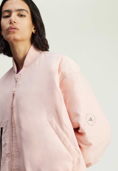 Pink bomber jacket with a smooth texture, zip front, and side pockets. Features a logo on the sleeve and ribbed cuffs.