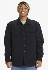 Schwarze Button-up-Hemd mit zwei Fronttaschen, aus strukturiertem Stoff, mit klassischem Kragen und Druckknöpfen.