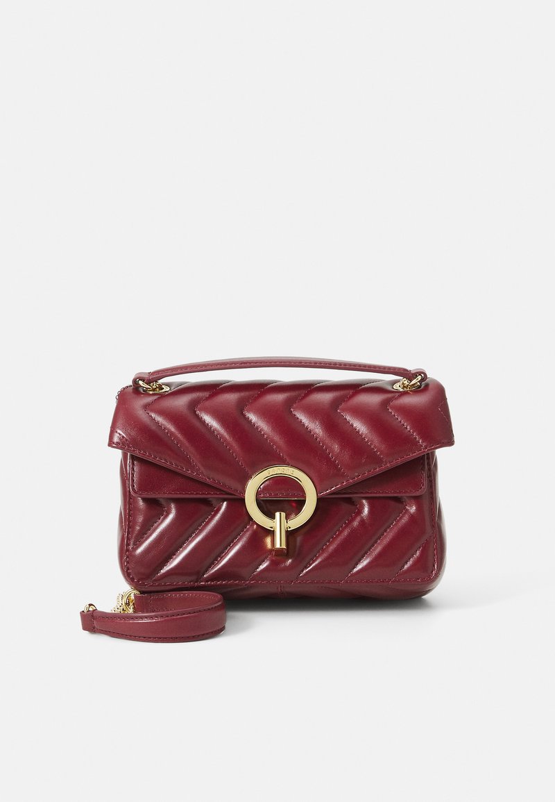 Burgundy bőr kézitáska chevron steppeléssel, arany kör alakú fém részletekkel, felül fogható kézi sürgősséggel és állítható vállpánttal. Kompakt és strukturált dizájn.