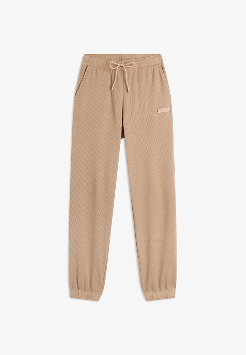 Joggers beige hechos de una tela texturizada con una cintura elástica, cierre de cordón y bolsillos laterales. Presentan un pequeño acento de logo.