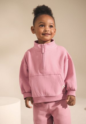Rosa Fleece-Pullover mit Halbreißverschluss am Ausschnitt und Vordertasche; ausgestattet mit gerippten Bündchen und Saum; weiche Textur, geeignet für Kinder.