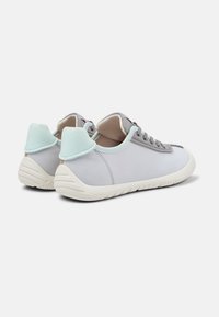 Sneakers in tessuto grigio con una trama liscia, suola in gomma bianca e dettagli azzurri chiari sul tallone. Presentano un design con lacci.