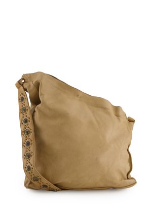 Soft tan leather shoulder bag with wide strap featuring round metal studs in decorative pattern against white background.