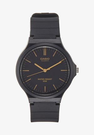 Zwarte kwarts horloge met een ronde wijzerplaat, gouden uurmarkeringen en wijzers. Heeft een gestructureerde zwarte silicium band en is waterbestendig tot 50 meter.