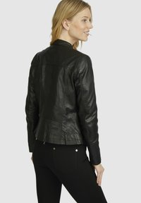 Black leather jacket with a fitted design, featuring a simple collar, rear seams, and a smooth texture, paired with black pants.