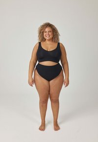 Czarny zestaw z biustonoszem i majtkami z wysokim stanem, charakteryzujący się gładką fakturą i minimalistycznym wzornictwem. Oba elementy mają szerokie ramiączka i wycięcie.