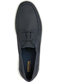 Zapato de cuero azul marino oscuro con textura suave, suela de goma blanca y diseño de cordones. Cuenta con el logotipo de Geox en dorado en la plantilla.