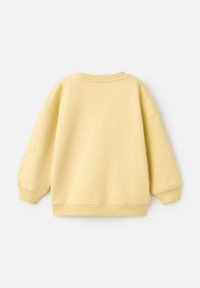 Effen lichtgele crewneck sweatshirt met lange mouwen en geribbelde boorden en zoom, plat weergegeven op een witte achtergrond.