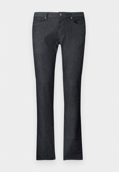 Tmavomodré rifle z denimu s priamym strihom nohavíc, ktoré majú predné a zadné vrecká, zapínanie na kovový gombík a jemné švy.