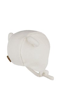 White fleece hat with small rounded ears, soft texture, and a chin strap tie. Features a brown accent label on the side.