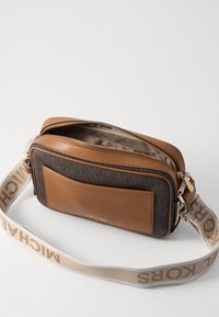 Borsa a tracolla in pelle marrone con fronte in tessuto decorato, chiusura con zip e tracolla removibile con nome del marchio in beige.
