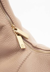 Borsa a tracolla in pelle color marrone chiaro con zip dorata e due etichette, che mette in risalto un esterno testurizzato e dettagli cuciti.