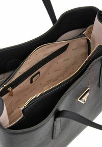 Borsa tote in pelle nera testurizzata con interno beige. Presenta una zip dorata e dettagli in metallo, più scomparti multipli e un dettaglio con logo.