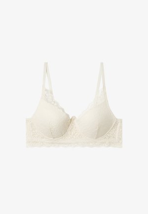 Lace bra in off-white with scalloped edges, adjustable straps, and molded cups featuring a floral pattern. Soft texture and seamless design.