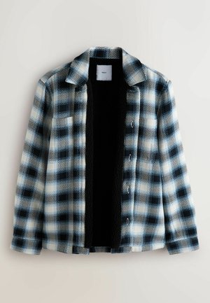 Giacca camicia a quadri in blu, nero e bianco. Presenta una chiusura frontale con bottoni, colletto appuntito e fodera in pile nero. Tessuto strutturato.