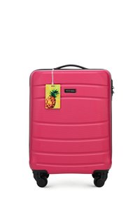 Roze harde koffer met een gestructureerd oppervlak, zwarte accenten, vier draaibare wielen en een kofferlabel in de vorm van een ananas.