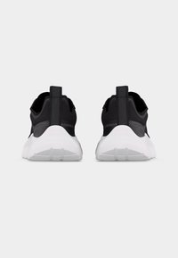 Ζευγάρι μαύρα αθλητικά παπούτσια με λευκές σόλες, ορατά από πίσω, σε απλό λευκό φόντο.