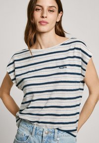 Striped t-shirt in navy and white with a relaxed fit, short sleeves, and a logo on the left side. Soft cotton material with a lightweight texture.