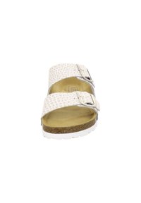White sandals with a textured upper, two adjustable buckles, cork footbed, and a white rubber sole. Open design for breathability.