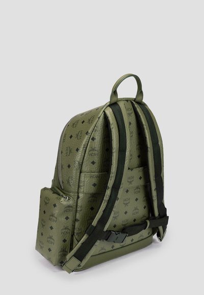 Zaino in pelle verde con motivi neri a logo, spallacci imbottiti e tasca laterale con zip. Forma arrotondata con manico superiore e texture robusta.