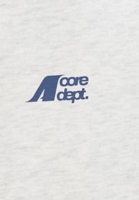 Tissu en coton blanc avec une surface texturée, arborant en évidence un logo "core dept." bleu, affiché dans une police moderne et audacieuse.