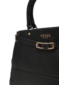 Borsa a mano in ecopelle nera con finitura testurizzata, caratterizzata da hardware tono oro, dettagli logo e manici superiori accentuati.