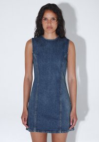 Mekko ilman hihoja, tummansininen, istuva muotoilu pyöreällä kaula-aukolla, risareunat ja näkyvät ompeleet, jotka luovat ryhdikkään siluetin.