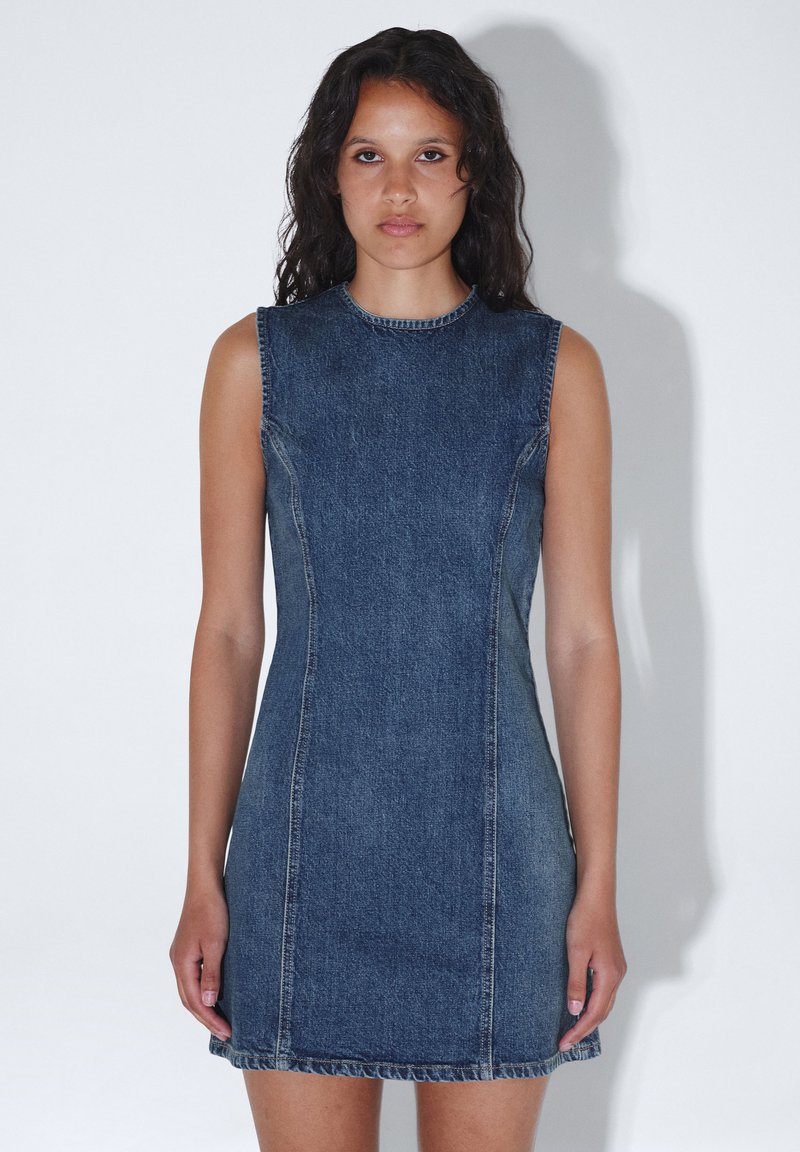 Mekko ilman hihoja, tummansininen, istuva muotoilu pyöreällä kaula-aukolla, risareunat ja näkyvät ompeleet, jotka luovat ryhdikkään siluetin.