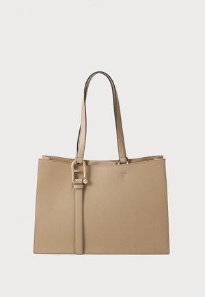 Beige leather tote bag with a structured design and gold hardware. Features two long handles and a detachable strap for versatility.