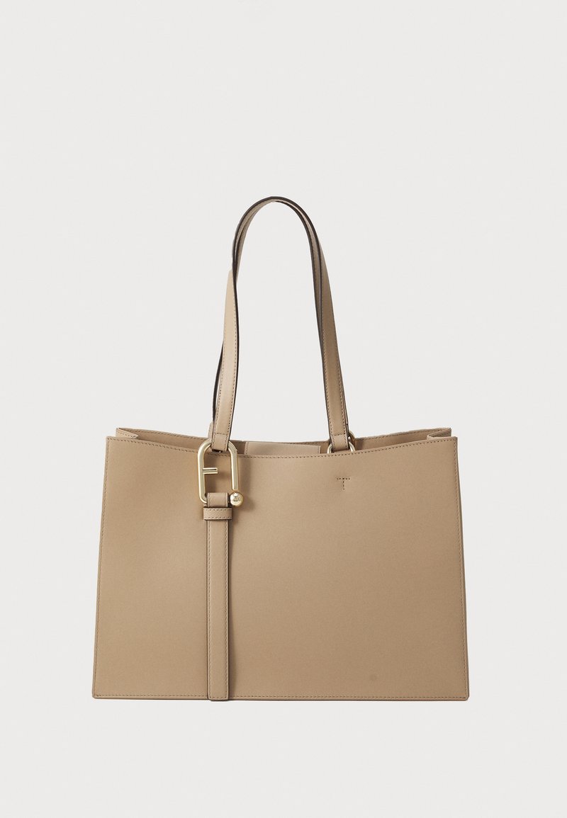 Sac fourre-tout en cuir beige avec un design structuré et du matériel doré. Il dispose de deux longues poignées et d'une sangle amovible pour plus de polyvalence.