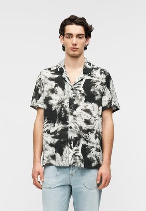 Schwarzes und weißes kurzärmeliges Hemd mit Blumenmuster, Reverskragen und durchgehender Knopfleiste, gefertigt aus leichtem Stoff.