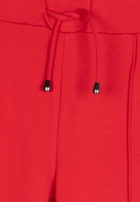 Rode joggingsbroek met een broekkoord in de taille en zwarte metalen uiteinden, een gladde textuur en een recht model.