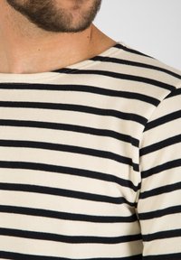 Langærmet stribet skjorte i creme og marineblå, med en båd-nakke og blødt, tekstureret stof med vandrette striber.