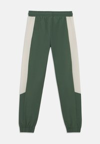 Πράσινο αθλητικό παντελόνι με αντίθετη μπεζ πλαϊνή ρίγα, ελαστική μέση και στενά μανσέτες. Μαλακό ύφασμα και μοντέρνο κόψιμο για άνεση.