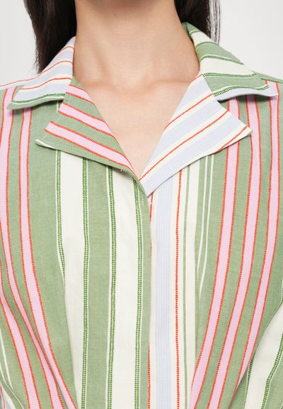 Chemise rayée avec un col. Présente des rayures verticales vertes, blanches et roses de différentes largeurs ainsi qu'un tissu doux et texturé.