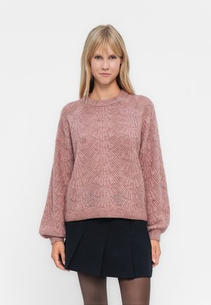 Lys rosa strikket genser med et strukturert mønster, rund hals og ballongsleeves. Kombinert med et mørkt plisserte skjørt.