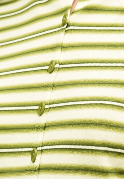 Ύφασμα με οριζόντιες ρίγες σε πράσινο και λευκό χρώμα, με τέσσερα πράσινα κουμπιά κεντραρισμένα και δεμένα κάθετα κατά μήκος της κεντρικής ραφής.